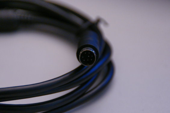 Close-up of a coiled black cable with a multi-pin connector