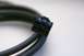 2003 Ford Taurus - A close-up view of a black cable and its multi-pin connector against a white background.