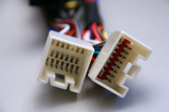Two white plastic wiring harness connectors with multiple wires
