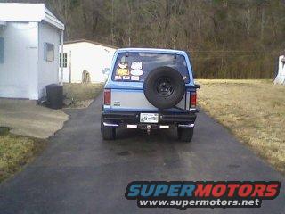 1985 Ford Bronco II rear view, blue with silver stripe and spare tire on back. License plate visible