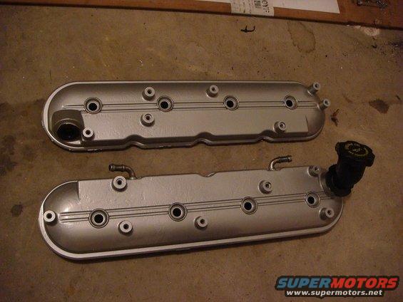 Two silver valve covers with black oil cap on one