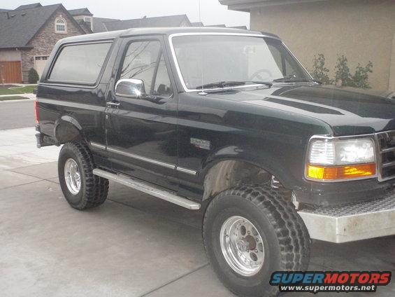 Dark green SUV parked in a driveway. It has chrome trim and aftermarket wheels
