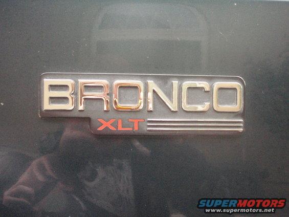 Bronco XLT badge on dark vehicle exterior. Reflection visible