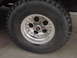 1993 Ford Bronco - A close-up view of a Cooper radial tire mounted on a chrome alloy wheel, a center cap with red and silver accents.