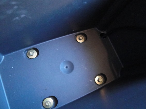 Interior plastic part with four visible bolts and a central circular indentation