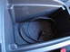 2003 Ford Taurus - The interior storage compartment holds a coiled black cable.