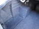 2003 Ford Taurus - The interior of a car trunk is shown, lined with dark grey carpet.