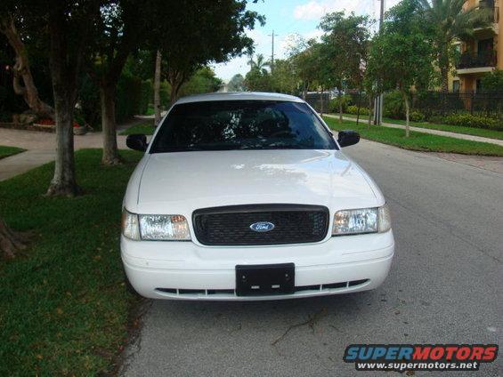 White 2002 Ford Crown Victoria parked on a residential street, front view