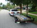 2002 Ford Crown Victoria - A white 2002 Ford Crown Victoria is seen from the rear, towing a trailer loaded with a ladder.