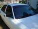 2002 Ford Crown Victoria - The side and front of a white 2002 Ford Crown Victoria with dark tinted windows is shown.