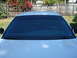 2002 Ford Crown Victoria - The front windshield of a car shows newly applied dark tinting, with the steering wheel visible inside.