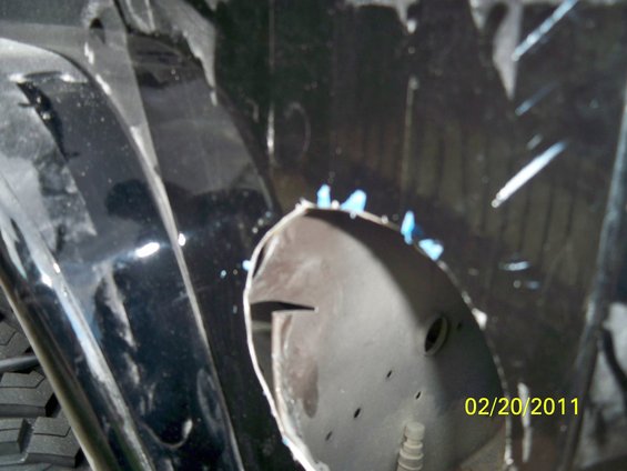 close-up of modified fender well with cutouts and blue paint flecks