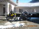 1965 Ford Mustang - Two men pose with their motorcycles in a driveway with snow on the ground.