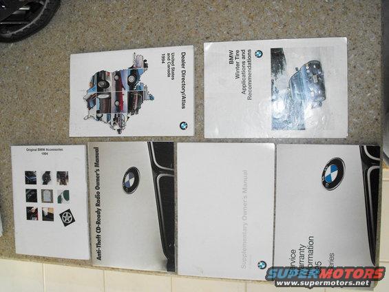 Several BMW manuals and a 1994 accessories catalog laid out on a floor