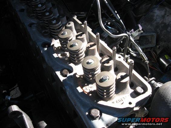 Close-up of an engine cylinder head showing valve springs and pushrods