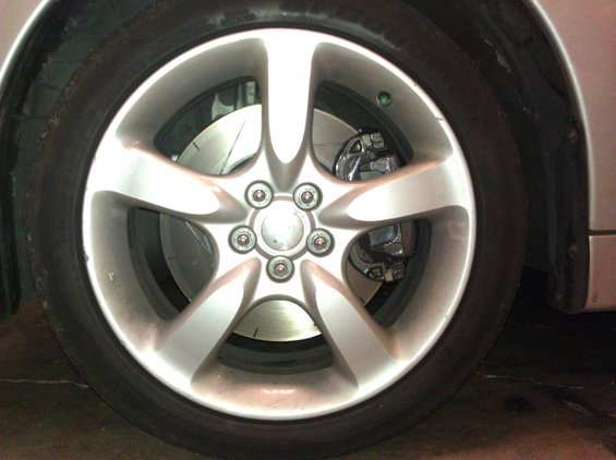 Silver five-spoke alloy wheel with a visible brake caliper and rotor