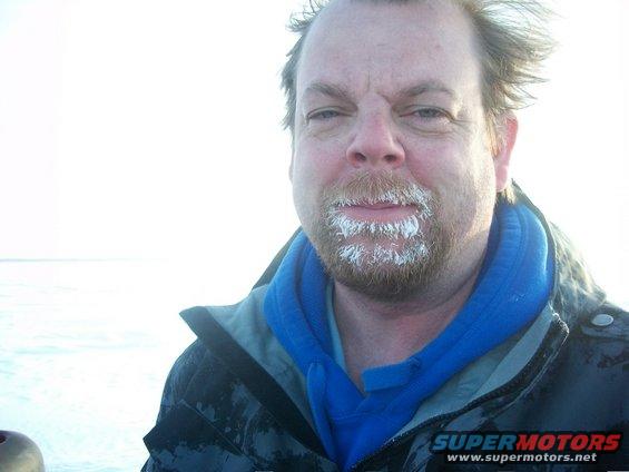 Man with frosted beard and blue hoodie, wearing a dark jacket