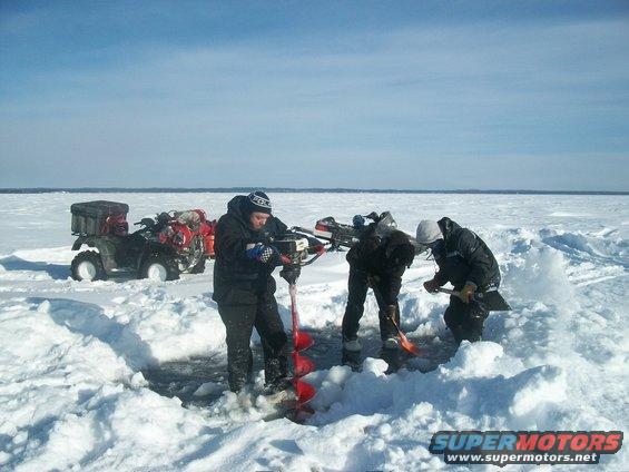 ATVs parked on ice with people ice fishing