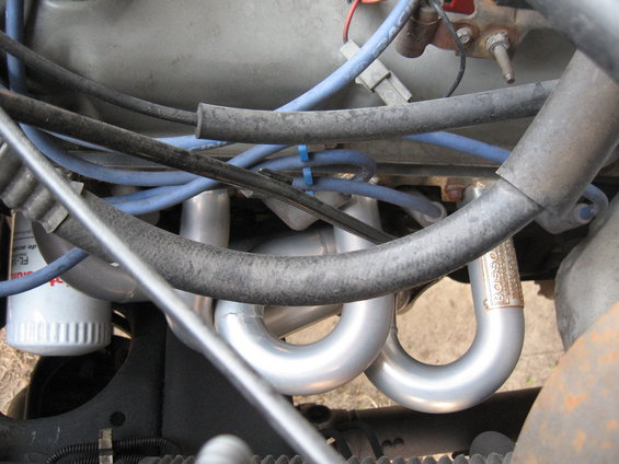 Engine compartment showing silver Bassani headers and blue spark plug wires