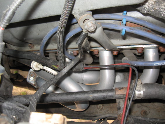 Engine exhaust headers with blue spark plug wires and black wiring