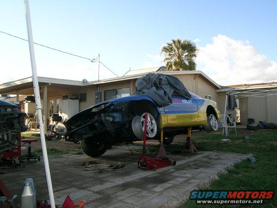 1995 Ford Probe on jack stands, blue and yellow livery with 'KELLY' text