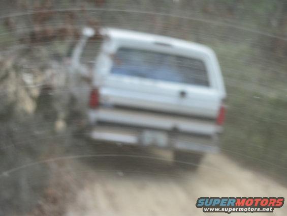 White SUV rear view on dirt road