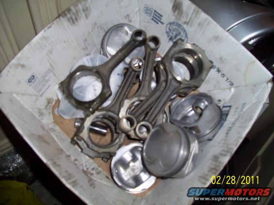 Engine pistons and connecting rods in a cardboard box