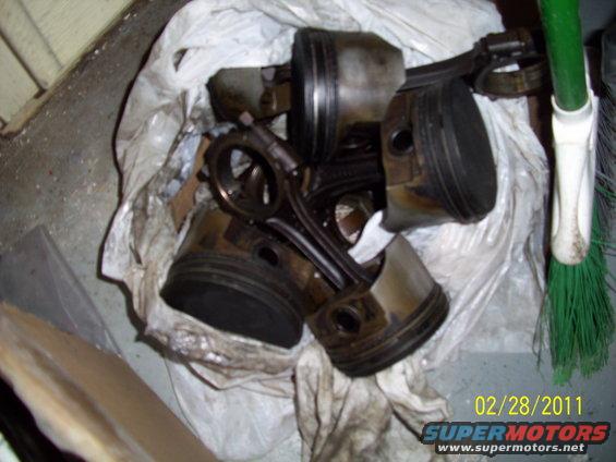 Pile of used pistons and connecting rods in a plastic bag