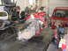 1993 Ford Taurus - An engine and transmission assembly is displayed on a workbench, with a red vehicle visible in the background of the garage.