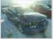 1993 Ford Probe - Damaged blue sedan in a snowy lot, with another vehicle in the background.
