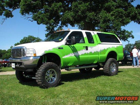 Lifted pickup truck, white and green paint, chrome wheels, 3/4 front view