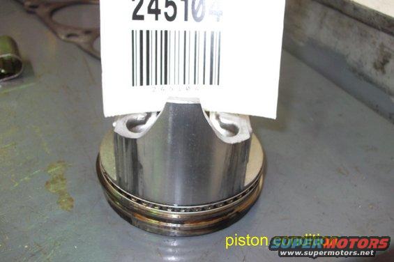 Engine piston with a white tag showing barcode and number 245104. Text 'piston SUPER MOTORS' visible