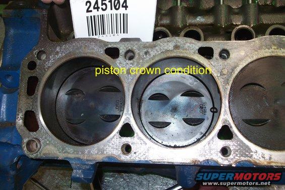 Engine block with pistons showing piston crown condition. Part number 245104 visible
