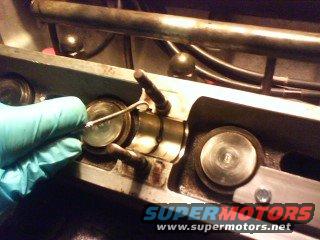 Removing lower half of cam bearing with pick tool.
