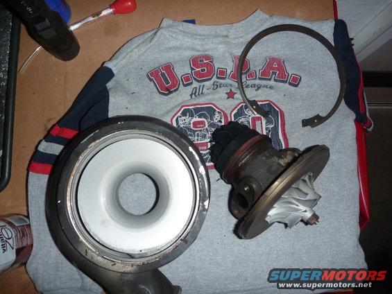 Turbocharger housing and wastegate assembly on a gray t-shirt with red and blue stripes on sleeves