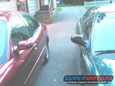 red sedan next to a dark sedan in a driveway