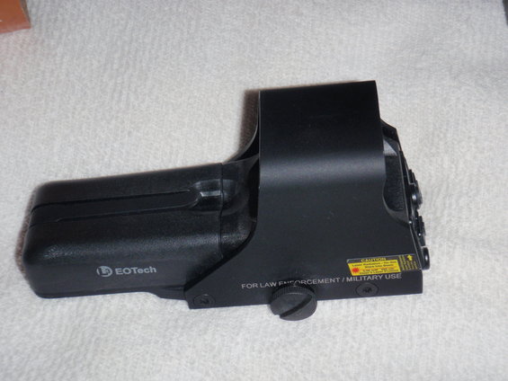 EOTech holographic sight with 'CAUTION LASER RADIATION' sticker and 'FOR LAW ENFORCEMENT / MILITARY USE' text