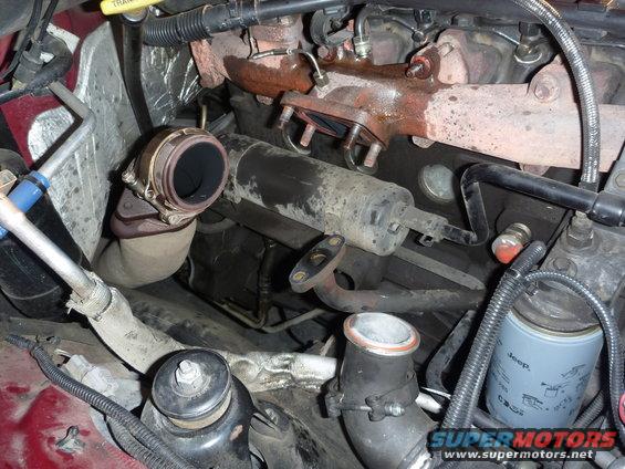 Engine compartment with turbocharger, exhaust manifold, and Jeep oil filter. Red paint visible