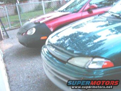 1997 Ford Taurus front end with a red car partially visible behind it