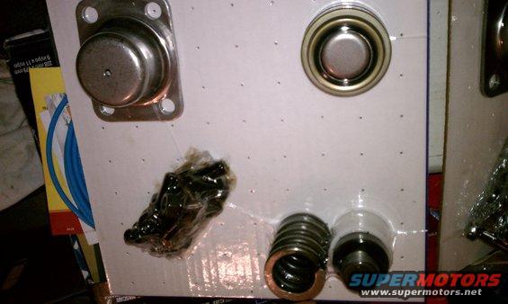 Automotive parts including springs and metal caps in clear plastic packaging