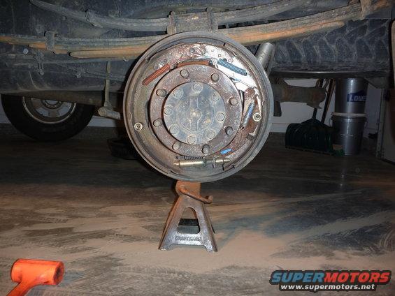 rear drum brake assembly on jack stand, leaf springs above