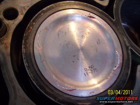 Piston with markings '0.50 11-775' and visible wear