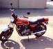 2008 Ford Crown Victoria - Kawasaki KZ1000 motorcycle with a red fuel tank and gold pinstripes.