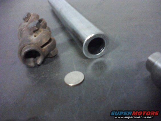Rusty U-joint and metal tube on a dark surface