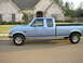 1995 Ford Bronco - This light blue pickup truck is parked on a suburban street in front of a house.