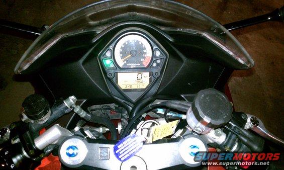 Motorcycle dashboard with analog tachometer and digital display showing 0 km/h and 348 miles
