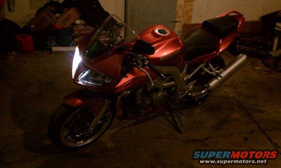 Red 2003 Suzuki SV1000S motorcycle parked indoors, front 3/4 view