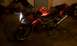 2003 Suzuki SV1000S - Red 2003 Suzuki SV1000S motorcycle with its headlights on.