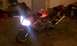 2003 Suzuki SV1000S - A red 2003 Suzuki SV1000S motorcycle is parked inside a garage with its headlights illuminated.