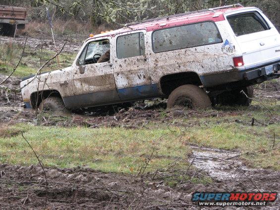 Mud-covered 1978 Chevrolet K5 Blazer stuck in mud, front passenger side wheel deep in mire